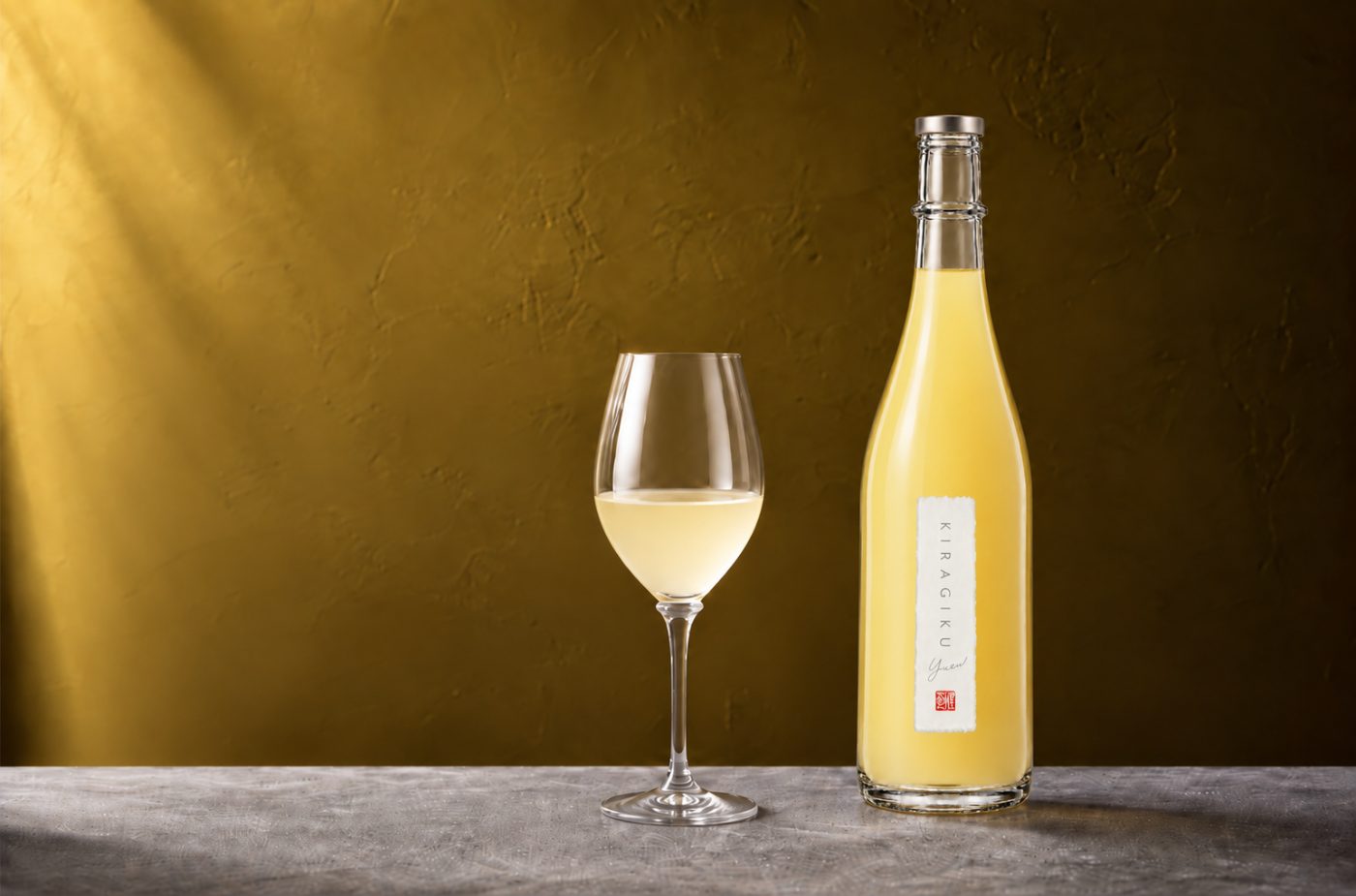 金色の壁の前に置かれた煌菊 YUZU BUNTANとワイングラス